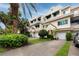 Two-story condo building with garages and lush landscaping at 4630 Mirabella Ct, St Pete Beach, FL 33706