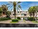 Front view of charming townhouses with lush landscaping and palm trees at 4630 Mirabella Ct, St Pete Beach, FL 33706