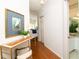 A hallway with a console table and art, leading to the bathroom at 4630 Mirabella Ct, St Pete Beach, FL 33706