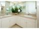 Double sink bathroom with updated cabinets and a large mirror at 4630 Mirabella Ct, St Pete Beach, FL 33706
