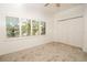 Bright bedroom with large window, carpet, and double doors to closet at 4630 Mirabella Ct, St Pete Beach, FL 33706