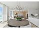 Elegant dining area with round wooden table, modern chandelier, and kitchen views at 1000 Water St # 1702, Tampa, FL 33602