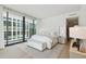 Main bedroom with plush bedding and floor to ceiling windows at 1000 Water St # 1702, Tampa, FL 33602