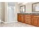 Bathroom featuring double sink vanity, granite countertop, large shower with glass door and tile floors at 27542 Sky Lake Circle, Wesley Chapel, FL 33544