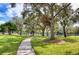 Beautiful community park with green grass, mature trees, sidewalk and a playground at 27542 Sky Lake Circle, Wesley Chapel, FL 33544