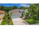Charming single-story home with well-manicured lawn, mature trees, and two-car garage offers great curb appeal at 27542 Sky Lake Circle, Wesley Chapel, FL 33544