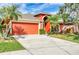 Inviting single-story home features a well-manicured lawn, palm trees, and two-car garage at 27542 Sky Lake Circle, Wesley Chapel, FL 33544