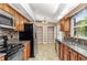 Modern kitchen with granite countertops, stainless steel appliances, mosaic backsplash, and wood cabinets at 27542 Sky Lake Circle, Wesley Chapel, FL 33544