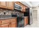 Kitchen features stainless steel appliances, granite countertops, mosaic backsplash, and wood cabinets at 27542 Sky Lake Circle, Wesley Chapel, FL 33544
