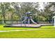 Community playground with multiple slides and play equipment surrounded by a black metal fence at 27542 Sky Lake Circle, Wesley Chapel, FL 33544
