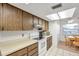 Kitchen boasts wood cabinets, white appliances, and tiled floor at 3840 Staysail Ln # 3840, Holiday, FL 34691