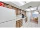 Bright kitchen with wood cabinets, white appliances, and tiled floor at 3840 Staysail Ln # 3840, Holiday, FL 34691