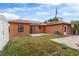 Expansive backyard showcasing the home's orange exterior, solar panels, and patio area at 460 48Th S St, St Petersburg, FL 33711