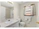 Bright bathroom featuring a granite vanity, toilet, and window, creating a comfortable and functional space at 460 48Th S St, St Petersburg, FL 33711