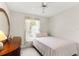 Well-lit bedroom features a single bed, wooden dresser, ceiling fan, and bright window at 460 48Th S St, St Petersburg, FL 33711