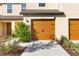 Two-car garage with tan doors and walkway at 5315 Companion Ln, Tampa, FL 33619
