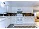 White kitchen cabinets, granite countertops, and a view into the living room at 5330 Vera St, Zephyrhills, FL 33542
