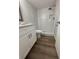 Modern bathroom with white tile shower and wood-look flooring at 2690 Coral Landings Blvd # 535, Palm Harbor, FL 34684