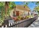 Lovely home featuring a cozy front porch, decorative iron railings, colorful flowers, and a dark picket fence at 2905 N 13Th St, Tampa, FL 33605