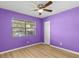 Purple bedroom with wood-look flooring and ceiling fan at 4045 Arrowwood Ct, Palm Harbor, FL 34684