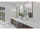Bright bathroom showcasing a double vanity with modern fixtures, stylish mirrors, and a view of the outside at 4633 W Lowell Ave, Tampa, FL 33629