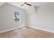 Bright bedroom with wood floors, ceiling fan, one window, and light gray walls and white trim at 4633 W Lowell Ave, Tampa, FL 33629