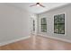 Bright bedroom with wood floors, two windows, ceiling fan, and light gray walls and white trim at 4633 W Lowell Ave, Tampa, FL 33629