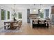 Combined dining and kitchen area features modern gray cabinets, large island, and oversized dining table at 4633 W Lowell Ave, Tampa, FL 33629