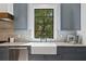 Kitchen sink with grey cabinetry, granite counters, and stainless appliances at 4633 W Lowell Ave, Tampa, FL 33629