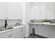 Bright laundry room with white cabinets, marble counters, modern fixtures, and stylish gray tile flooring at 4633 W Lowell Ave, Tampa, FL 33629