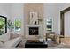 Elegant living room has a stone fireplace, natural light, and stylish seating for a warm and inviting atmosphere at 4633 W Lowell Ave, Tampa, FL 33629