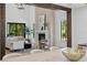 Open-concept living room with a stone fireplace, wood beams, and natural light at 4633 W Lowell Ave, Tampa, FL 33629
