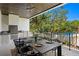 Outdoor dining area with a built-in grill and seating for eight, overlooking the pool at 4633 W Lowell Ave, Tampa, FL 33629