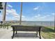 Serene waterfront view with a park bench and pier in the background at 1505 Cedar St, Safety Harbor, FL 34695