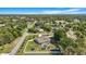 Wide aerial view of property featuring screened in pool, fenced yard, and lush landscaping at 15272 Spinning Wheel Ln, Brooksville, FL 34604