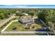 Drone-eye view featuring an enclosed pool, well-manicured lawn, and neighborhood landscape at 15272 Spinning Wheel Ln, Brooksville, FL 34604