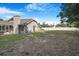 The rear of the house shows a backyard featuring a chimney and a white fence at 15272 Spinning Wheel Ln, Brooksville, FL 34604