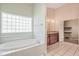 Bathroom with a soaking tub and a granite-topped vanity at 15272 Spinning Wheel Ln, Brooksville, FL 34604