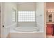 Bathroom with a soaking tub and a unique glass block window at 15272 Spinning Wheel Ln, Brooksville, FL 34604