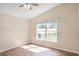 Comfortable bedroom with wood floors and a large window, creating a serene and inviting space at 15272 Spinning Wheel Ln, Brooksville, FL 34604
