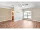 Bright bedroom with wood floors, a ceiling fan, and a large window offering plenty of natural light at 15272 Spinning Wheel Ln, Brooksville, FL 34604