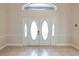 Bright foyer with double doors, tile flooring, and transom window, creating a welcoming entrance to the home at 15272 Spinning Wheel Ln, Brooksville, FL 34604