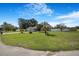 Expansive front yard with mature landscaping and a well-maintained lawn showcases curb appeal at 15272 Spinning Wheel Ln, Brooksville, FL 34604
