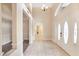 Bright foyer with double doors, chandelier, neutral tile flooring, and access to other rooms at 15272 Spinning Wheel Ln, Brooksville, FL 34604