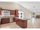 Open concept kitchen with dark wood cabinetry, granite countertops and an island, seamlessly connected to the living area at 15272 Spinning Wheel Ln, Brooksville, FL 34604