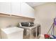 Functional laundry room with a sink, washer, dryer and ample cabinet space at 15272 Spinning Wheel Ln, Brooksville, FL 34604