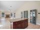 Open floor plan with view of fireplace, kitchen, display cabinets, and tiled flooring at 15272 Spinning Wheel Ln, Brooksville, FL 34604