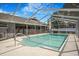 A screened-in pool with clear blue water and a metal frame for enjoying outdoor activities in any weather at 15272 Spinning Wheel Ln, Brooksville, FL 34604