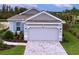 Single-story home with gray siding, tile roof, and landscaped yard at 29456 Velletri Ln, Wesley Chapel, FL 33543