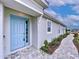 Light blue front door with a stone walkway leading to the entry at 29456 Velletri Ln, Wesley Chapel, FL 33543